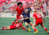 Arron Reed of Scotland runs at Canada defence during 2024 summer international