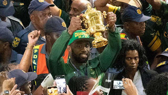 Siya Kolisi carries the Webb Ellis Cup through OR Tambo International Airport